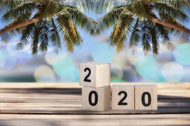 istock Wood cube number 2020 on planks on tropical beach background 1023562988