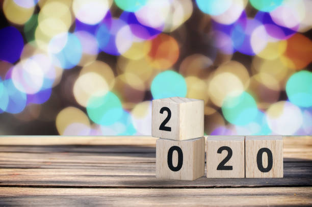 istock Wooden cube number 2020 on plank and abstract bokeh background 1023563006
