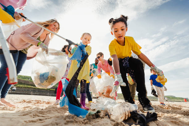 gruppi di volontari della comunità sulla spiaggia - sand clean beach sea foto e immagini stock