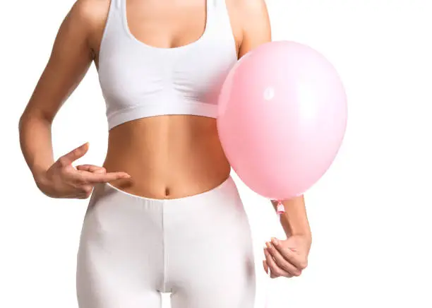 Beautiful young woman holding a pink balloon