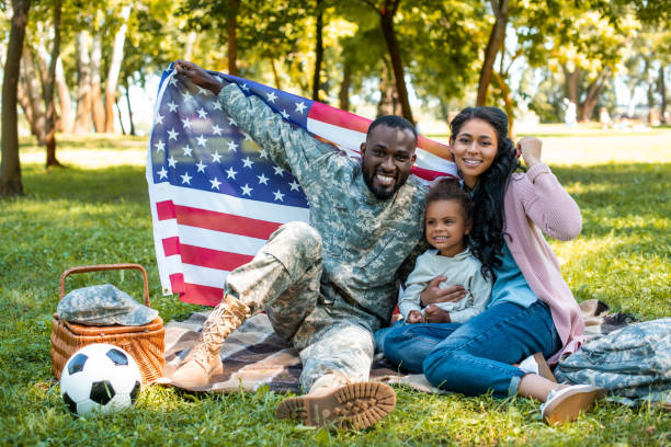 ミリタリー制服で公園でアメリカの国旗を保持している家族の幸せのアフリカ系アメリカ人兵士 - preschooler child offspring purity ストックフォトと画像