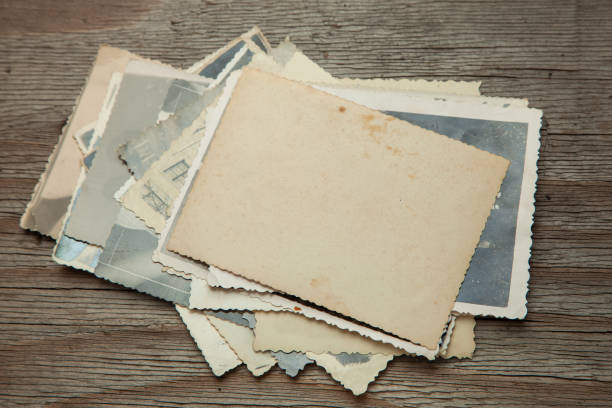 istock Stack old photos on table. Mock-up blank paper. Postcard rumpled and dirty vintage 1023588562