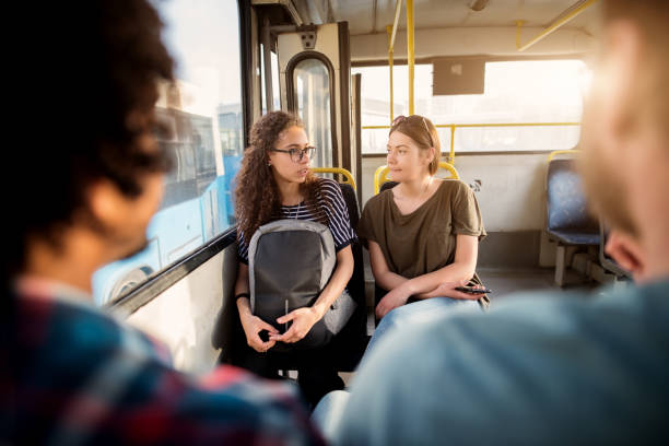 istock Two young student girls are talking in a bus. 1023588568