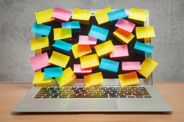 istock Laptop full display in reminders of colored stickers on table with gray wall 1023588670
