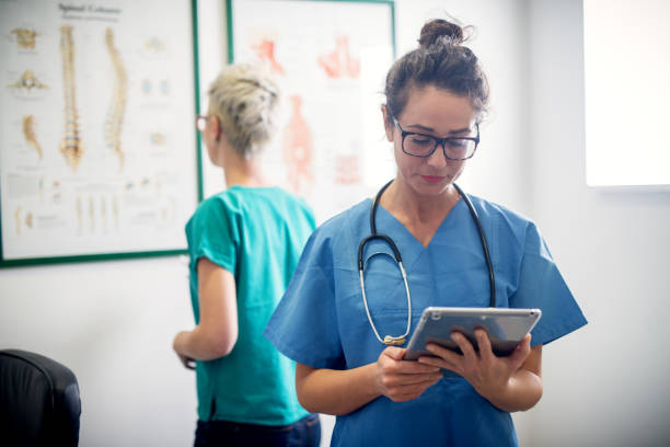 istock Two professional nurses in office looking through some medical procedure. 1023589238