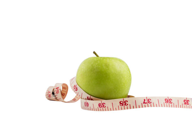 Isolate green apple on white bakcground with Measuring tape around.