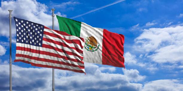 istock Mexico and America waving flags on blue sky. 3d illustration 1023605298