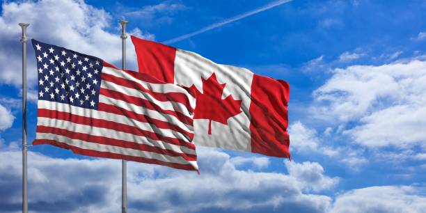 istock Canada and America waving flags on blue sky. 3d illustration 1023607400