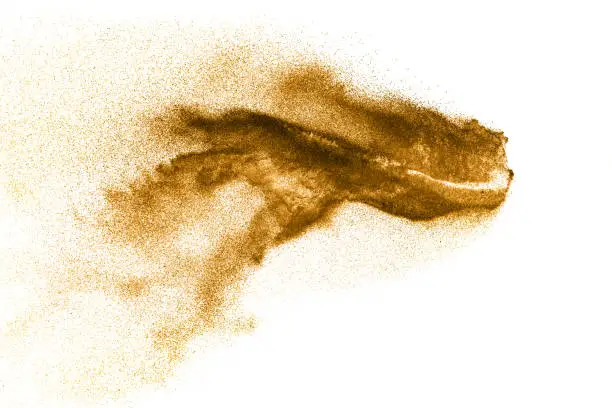 Golden sand explosion isolated on white background. Abstract sand cloud.