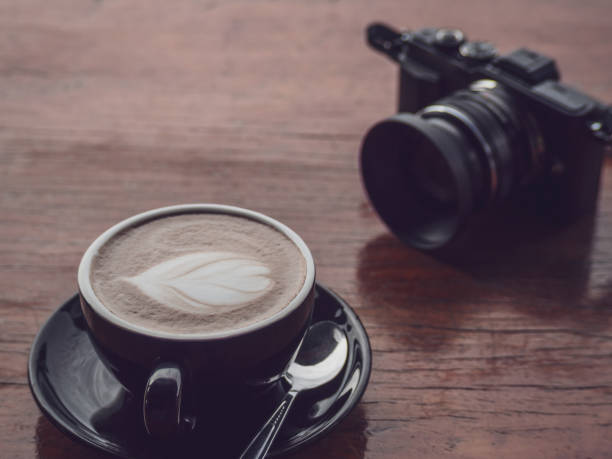 istock Hot coffee in black cup with camera 1023612248