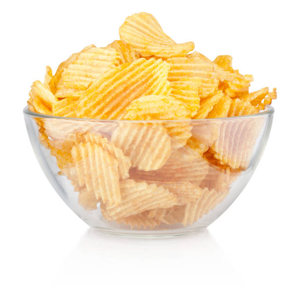 Crinkle cut potato chips in bowl isolated on a white background Crinkle cut potato chips in bowl isolated on a white background crisps stock pictures, royalty-free photos & images