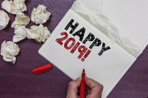 istock Handwriting text Happy 2019. Concept meaning time or day at which a new calendar year begin from now Man holding marker notebook page crumpled papers several tries mistakes 1023623336