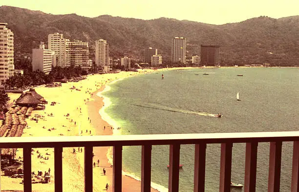 Vintage image of a beach in Acapulco viewed from a balcony.