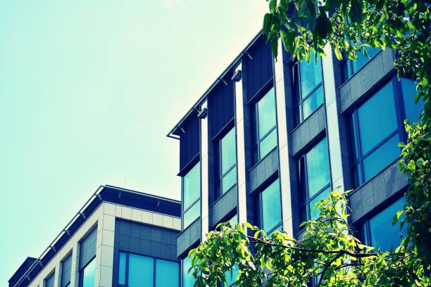 istock Modern office building on a clear sky background. Retro stylized colorful tonal filter effect 1023629874