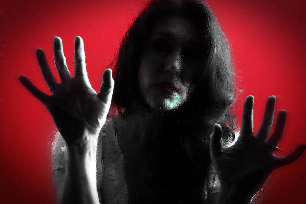 istock Female Trapped Behind Wet Glass on Red Background 1023634254