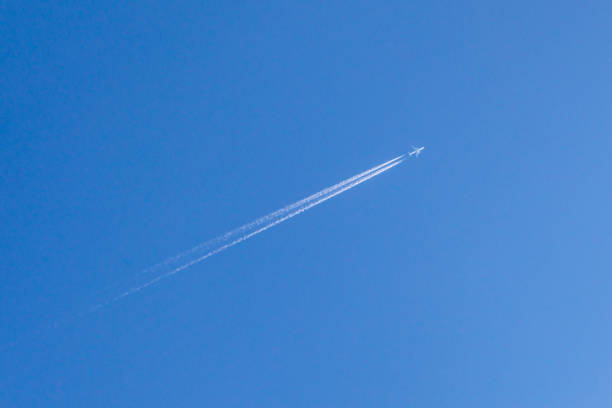 Jet. Inversion trace of the aircraft. Blue sky. The vanishing trace of the plane