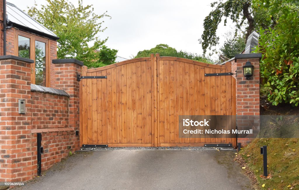 Wooden security gate with keypad operated lock A wooden security gate on the driveway of a residential house with keypad operated lock Gate Stock Photo