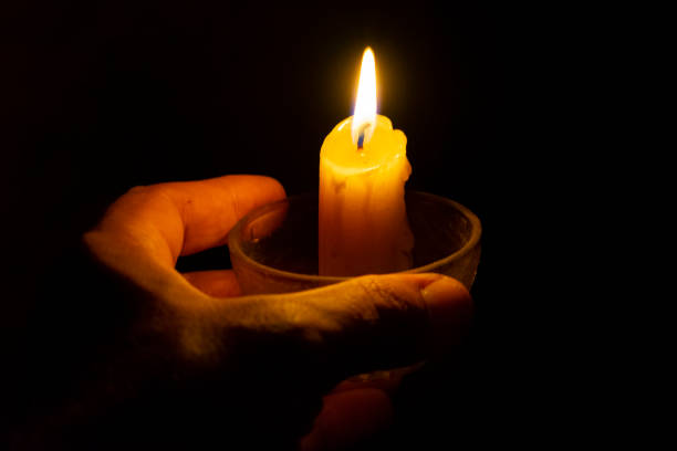 istock small candle in hand against a background of darkness 1023635852