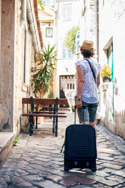 istock Tourist walking with suitcase on the street 1023639128