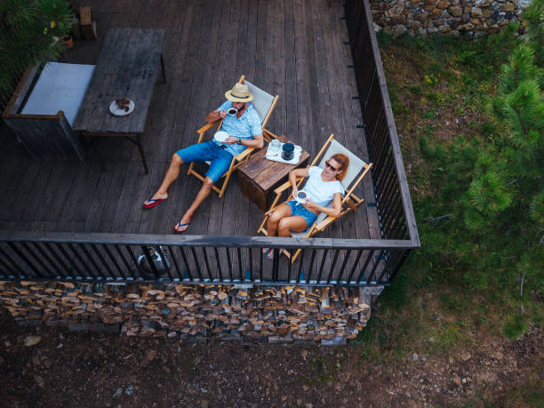 Young couple drinking coffee on terrace, aerial view