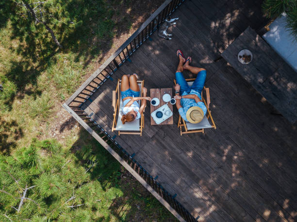 молодая пара пьет кофе на террасе, вид с воздуха - summer people furniture vacations стоковые фото и изображения