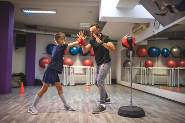 istock Young child learning boxing from his personal trainer 1023646344