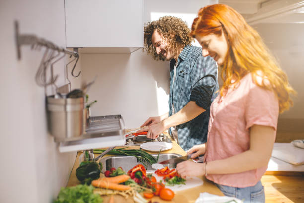 istock Lovely modern redhead couple preparing lunch together 1023658080