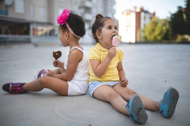 симпатичные грязные дети едят мороженое на открытом воздухе - child looking messy urban scene стоковые фото и изображения