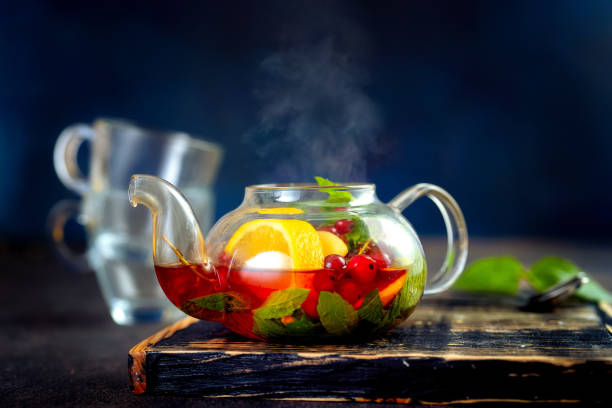 istock Teapot with hot fruit tea on dark background 1023665872