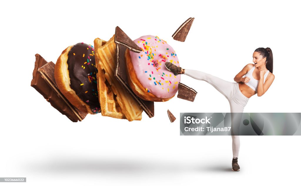 Fit young woman fighting off sweets and candy Sugar - Food Stock Photo