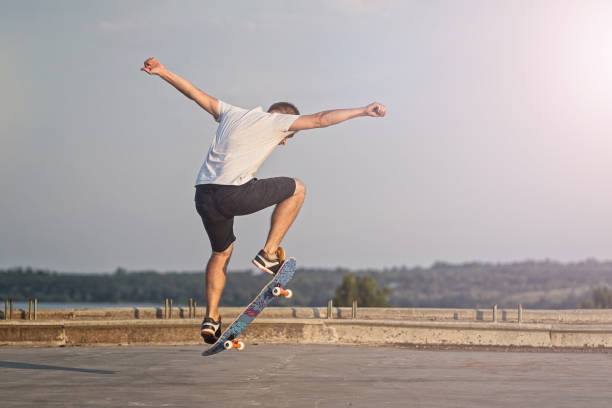 istock Skateboarder doing an ollie trick on background of blue sky. 1023666308