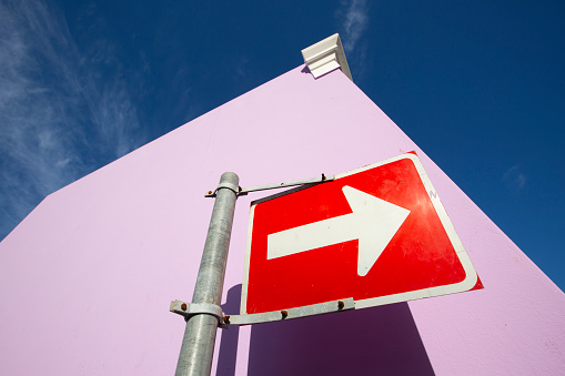 One way sign pointing the way up a street in a colourful and vibrant neighbourhood of Bo Kaap in the Cape Malay area of Cape Town