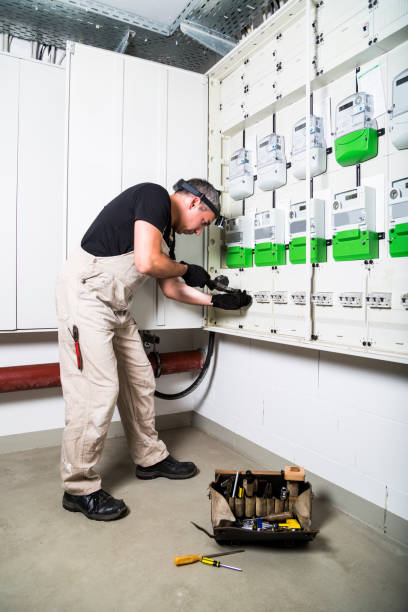 istock Electrician with box of tools testing fuse box or switch box by measuring device 1023674564