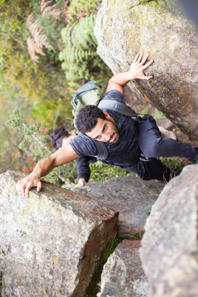 istock Couple climbing a huge rock 1023675440