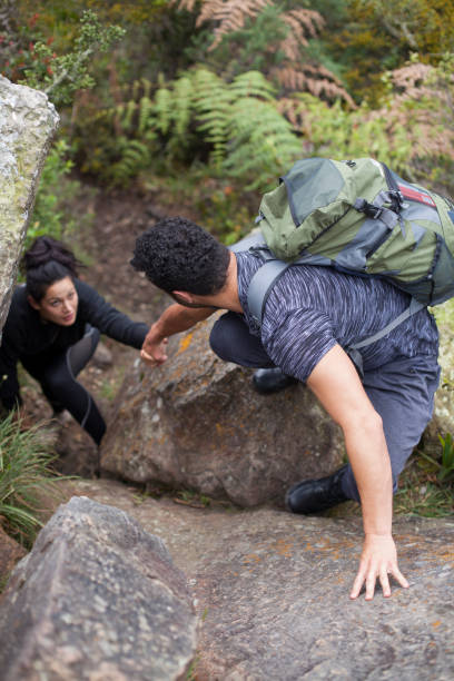 istock Couple climbing a huge rock 1023679916