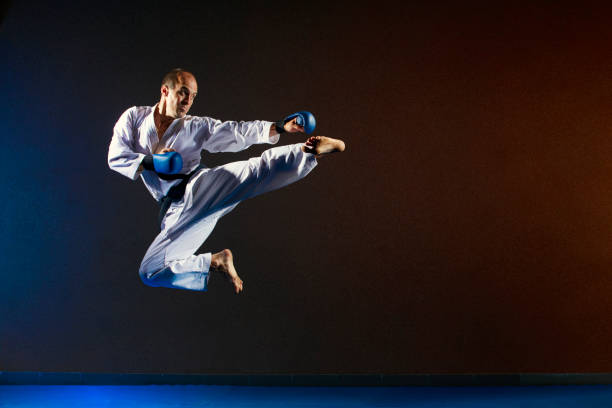 istock A man with blue overlays on his hands beats a kick in a jump 1023680456