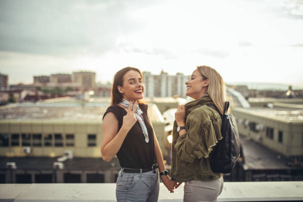 istock Beautiful young twins sisters relaxing on a rooftop in a city 1023683054