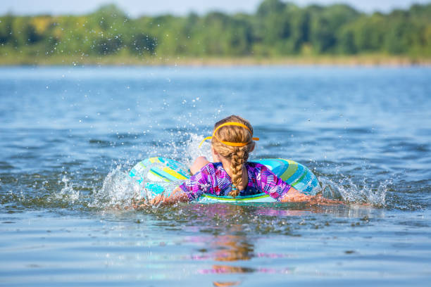 istock Girl Splashing In Water While Lying in Inner Tube Float 1023711950