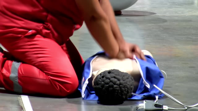 Health care worker performing CPR on mannequin side view