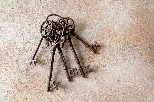 Bunch of old cast-iron keys on concrete background. Copy space for text.