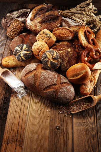 istock Different kinds of bread and bread rolls on board from above. Kitchen or bakery 1023724240