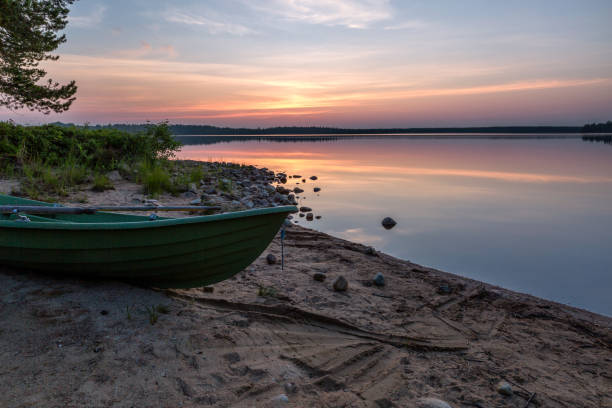 istock Beautiful morning on the like with green boat on foreground 1023735764