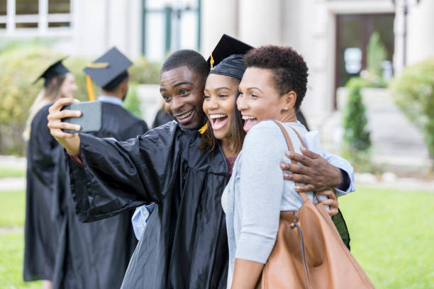 istock College graduate taking selfie with parents 1023742030
