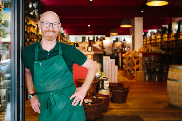 ritratto di un imprenditore ridendo di fronte alla sua enoteca - liquor store foto e immagini stock