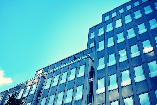istock Modern office building on a clear sky background. Retro stylized colorful tonal filter effect 1023759488