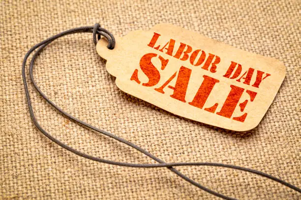 Labor Day sale sign - a paper price tag with a twine against burlap canvas