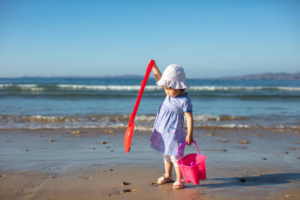 istock baby girl playing at summer beach 1023766694