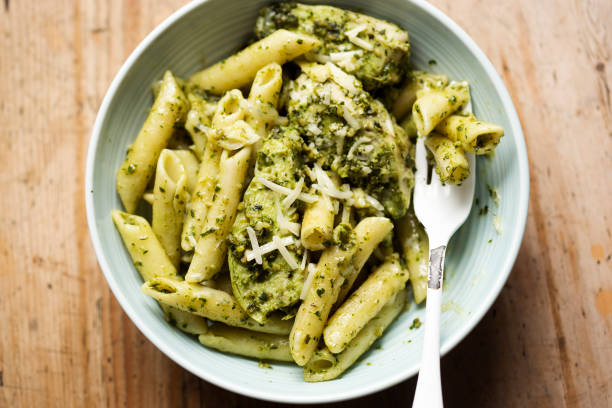 Green pesto chicken pasta with parmesan stock photo