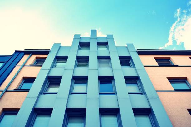 istock Modern office building on a clear sky background. Retro stylized colorful tonal filter effect 1023769864