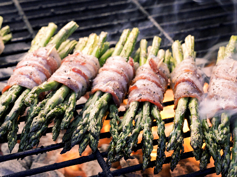 Part of a ketogenic or low carb diet, Bacon-wrapped asparagus on a flaming grill